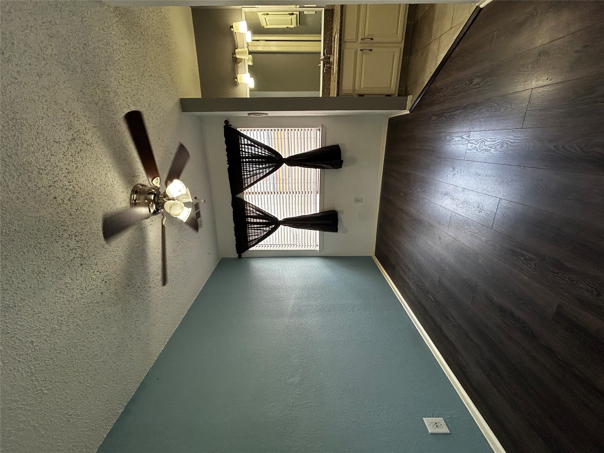 708 Graham Place, Unit 208 Austin, TX 78705 - Photo 4 of 9 Unfurnished bedroom featuring wood finished floors, a textured ceiling, a ceiling fan, ensuite bathroom, and a textured wall