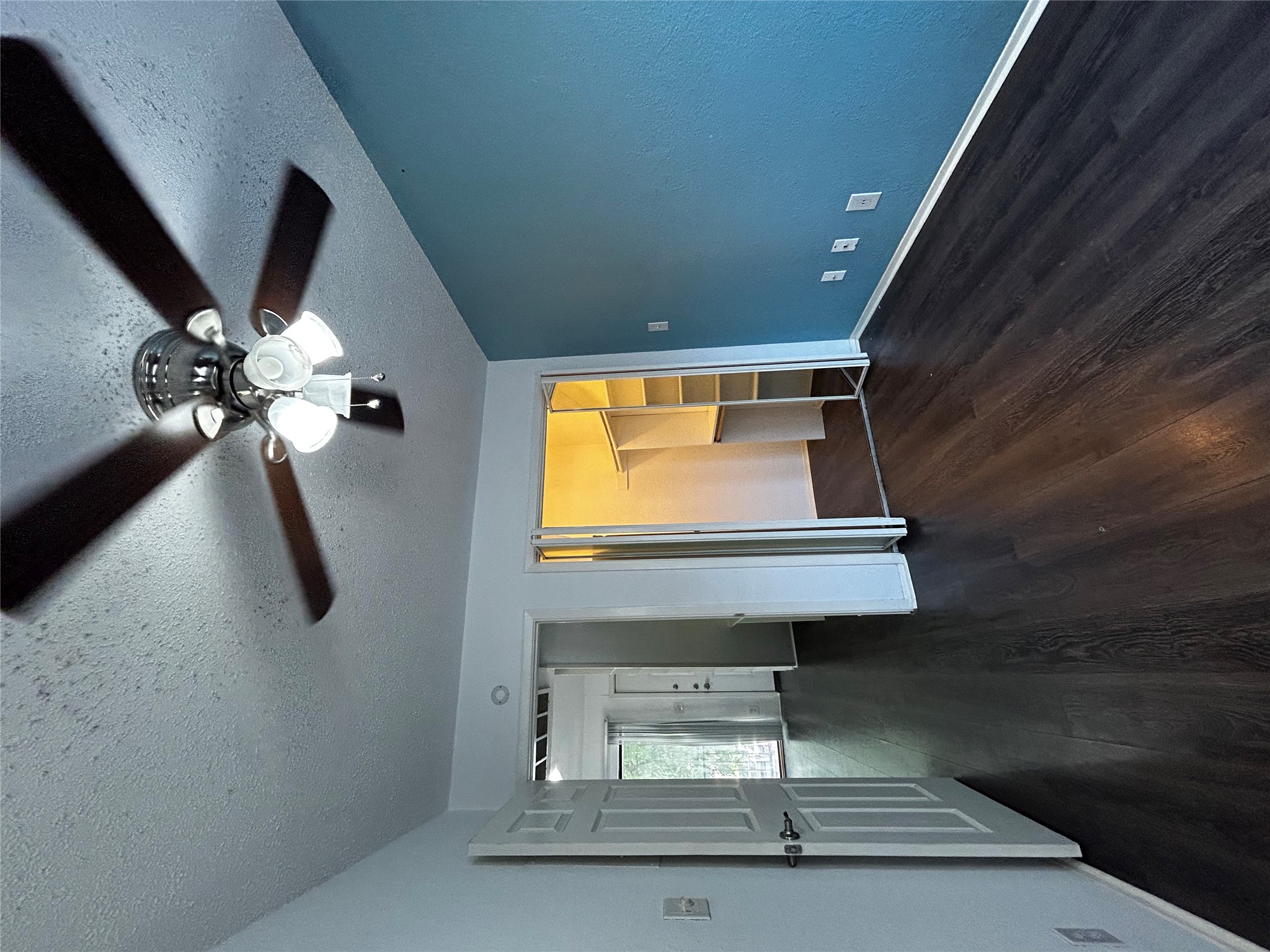 708 Graham Place, Unit 208 Austin, TX 78705 - Photo 5 of 9 Unfurnished bedroom featuring dark wood finished floors, a textured ceiling, a walk in closet, and a ceiling fan