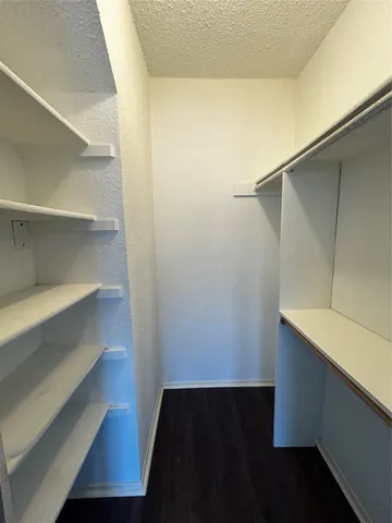 a view of walk in closet with empty racks