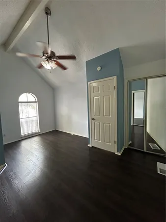 a view of a livingroom with wooden floor and a ceiling fan