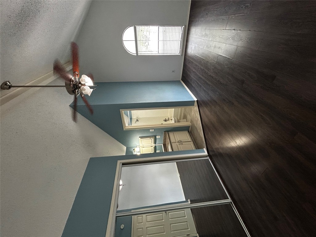 708 Graham Place, Unit 208 Austin, TX 78705 - Photo 8 of 9 a view of a livingroom with wooden floor and a ceiling fan