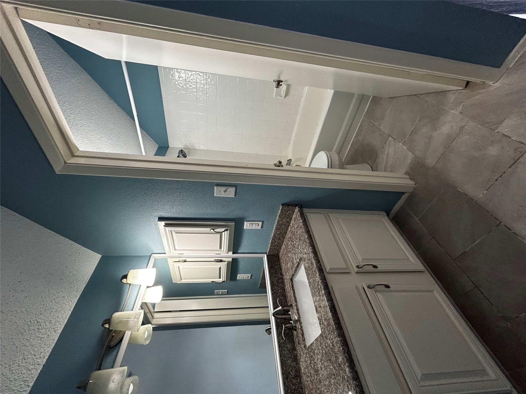 708 Graham Place, Unit 208 Austin, TX 78705 - Photo 9 of 9 Bathroom with a textured ceiling, vanity, bathing tub / shower combination, a textured wall, and vaulted ceiling