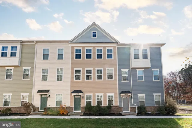 a front view of residential houses with yard and green space