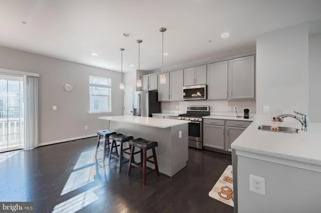 a kitchen with a stove a sink a window and wooden floor