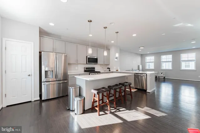 a kitchen with a refrigerator a sink cabinets and wooden floor