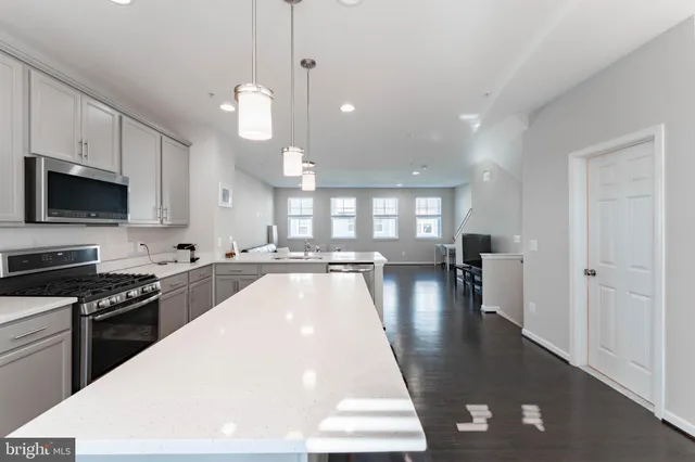 a kitchen with a refrigerator a sink and a stove top oven