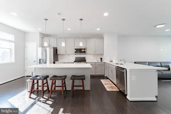 a kitchen that has a lot of cabinets in it with wooden floor and appliances