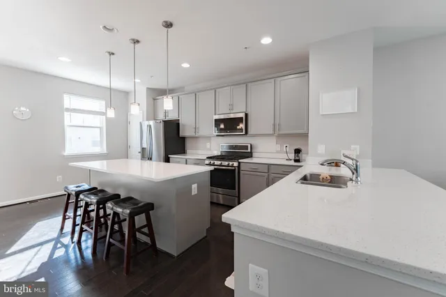 a kitchen with a sink a microwave and wooden floor
