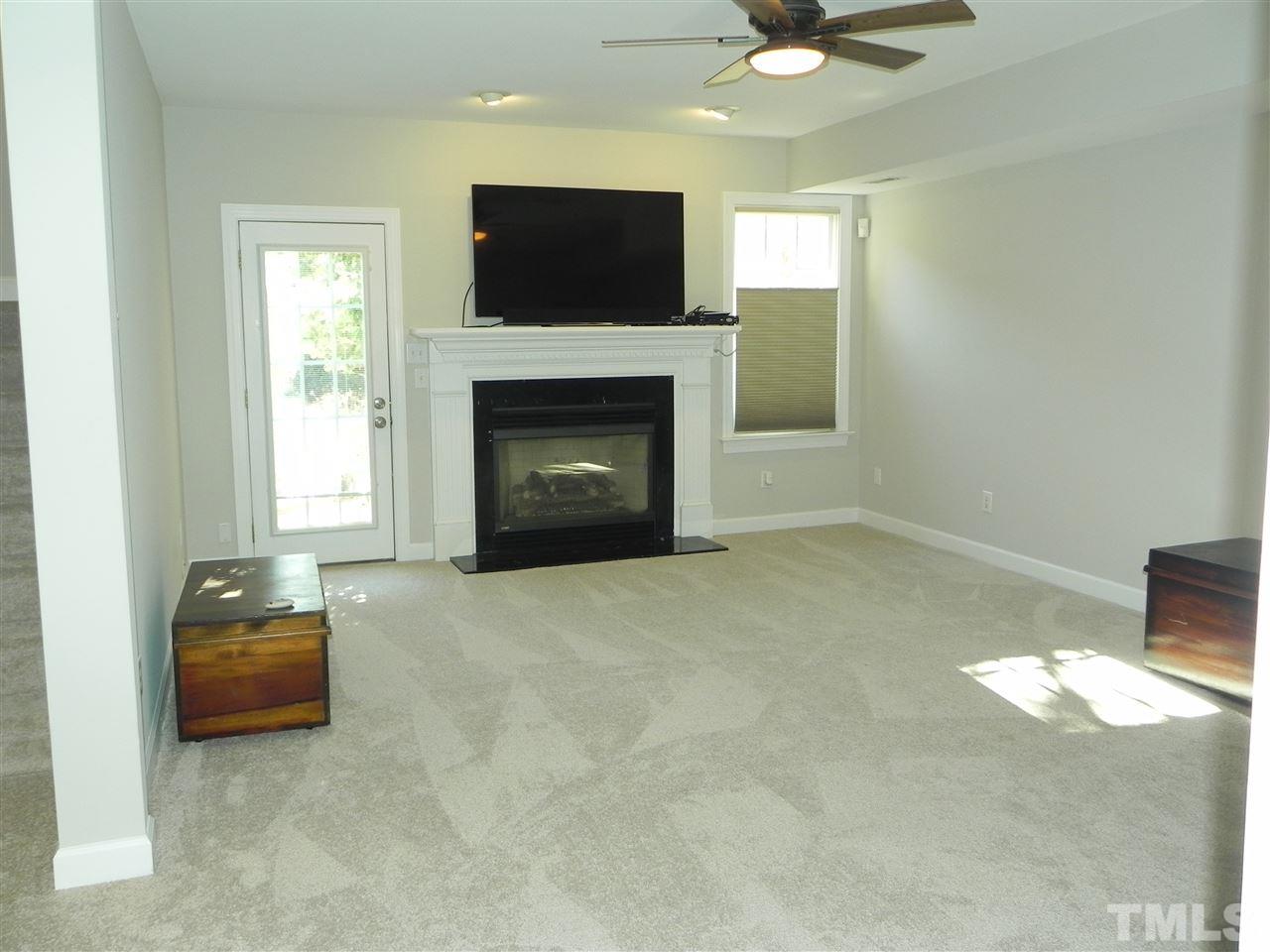 5505 Overleaf Court Raleigh, NC 27615 - Photo 19 of 25 Finished By the Builder, The Finished Basement Space Provides the Same Quality Finish as Upstairs. This Family Room Offers Great Space with the Fireplace and Walk Out to a Lovely Patio Area