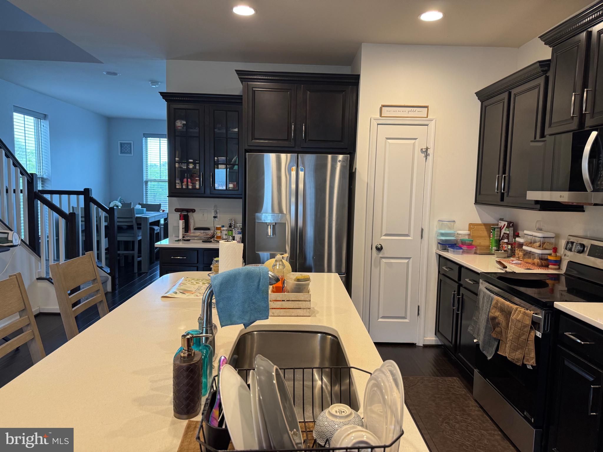 8937 Garrett Way Manassas, VA 20112 - Photo 21 of 66 a large kitchen with stainless steel appliances a stove a refrigerator a sink a dining table and chairs