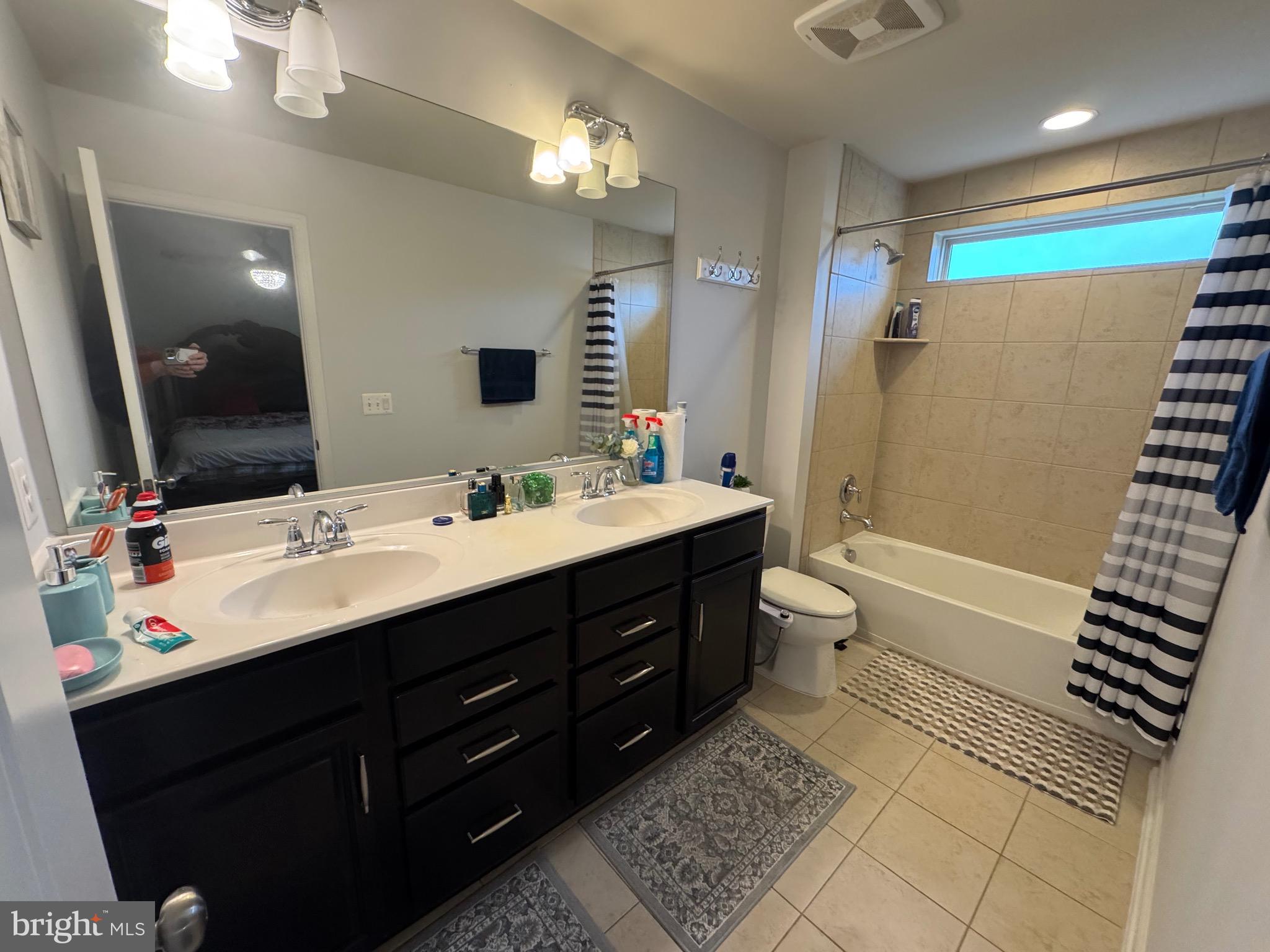 8937 Garrett Way Manassas, VA 20112 - Photo 40 of 66 a bathroom with a double vanity sink a toilet a mirror and shower