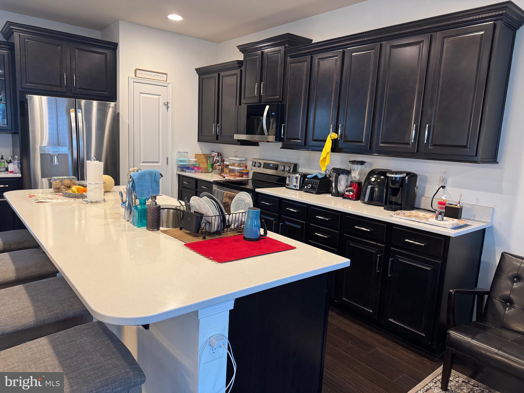 8937 Garrett Way Manassas, VA 20112 - Photo 7 of 66 a kitchen with stainless steel appliances kitchen island granite countertop a sink dishwasher and cabinets with wooden floor