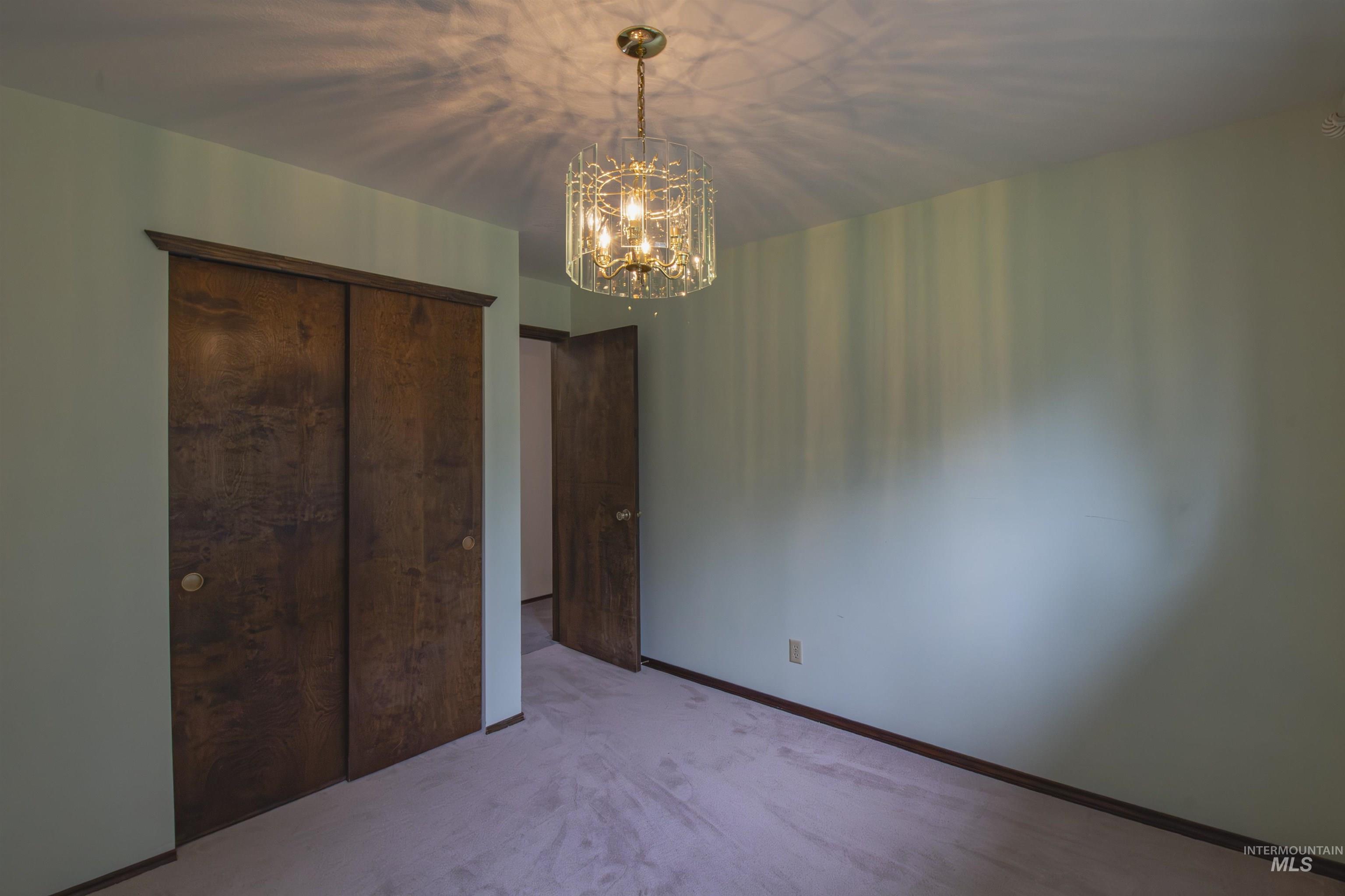 2465 Center Avenue Payette, ID 83661 - Photo 16 of 39 Unfurnished bedroom with hanging lights, light carpet, and a closet