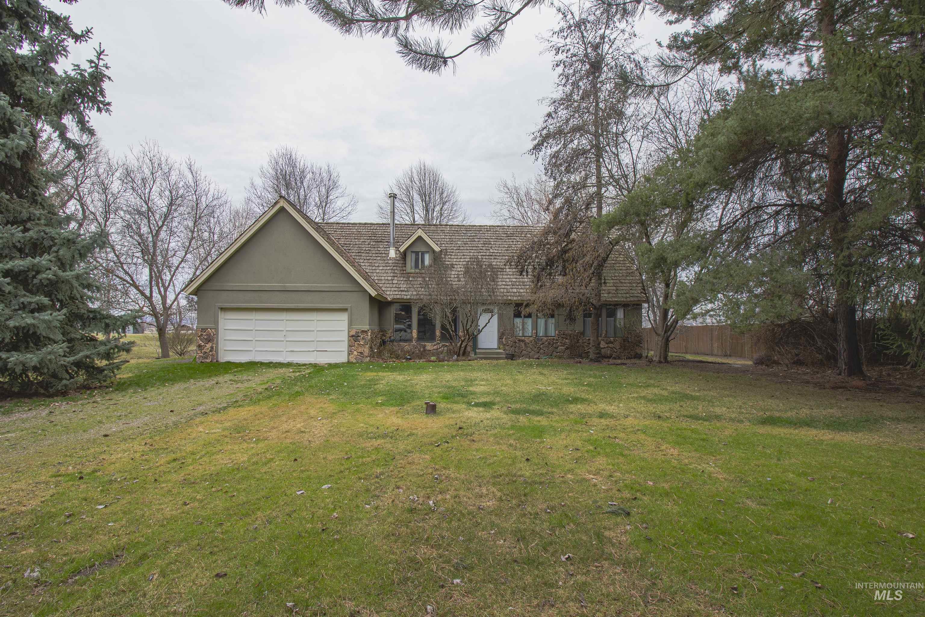 2465 Center Avenue Payette, ID 83661 - Photo 37 of 39 New england style home featuring stucco siding, stone siding, and an attached garage