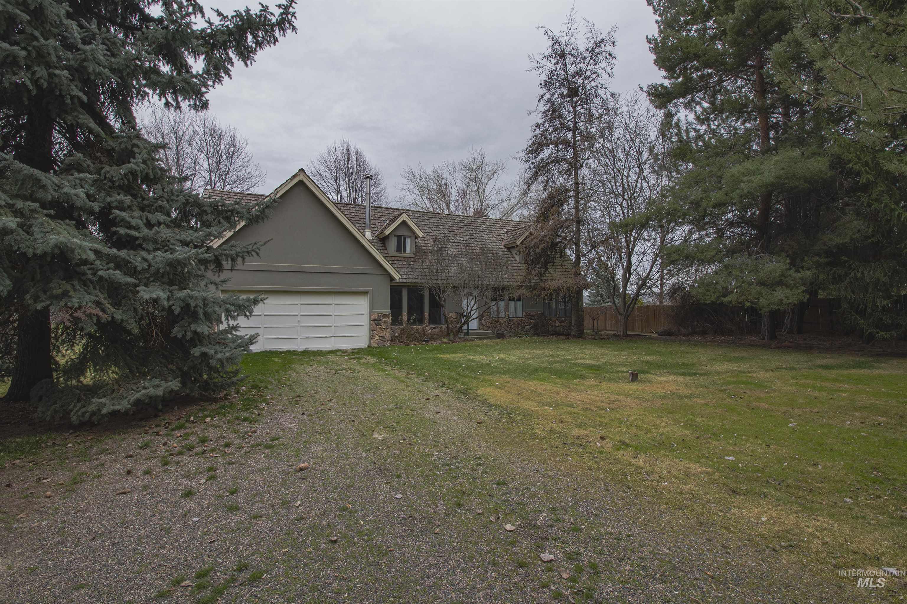 2465 Center Avenue Payette, ID 83661 - Photo 38 of 39 View of front of house featuring dirt driveway, stucco siding, an attached garage, and stone siding