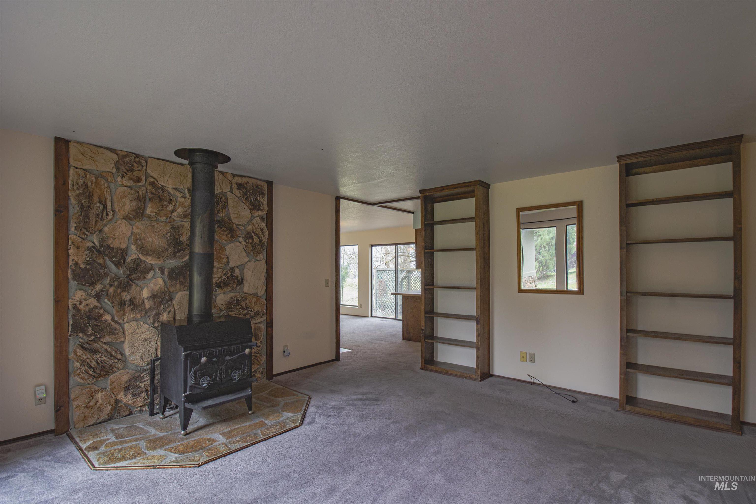 2465 Center Avenue Payette, ID 83661 - Photo 6 of 39 Unfurnished living room featuring a wood stove and carpet flooring