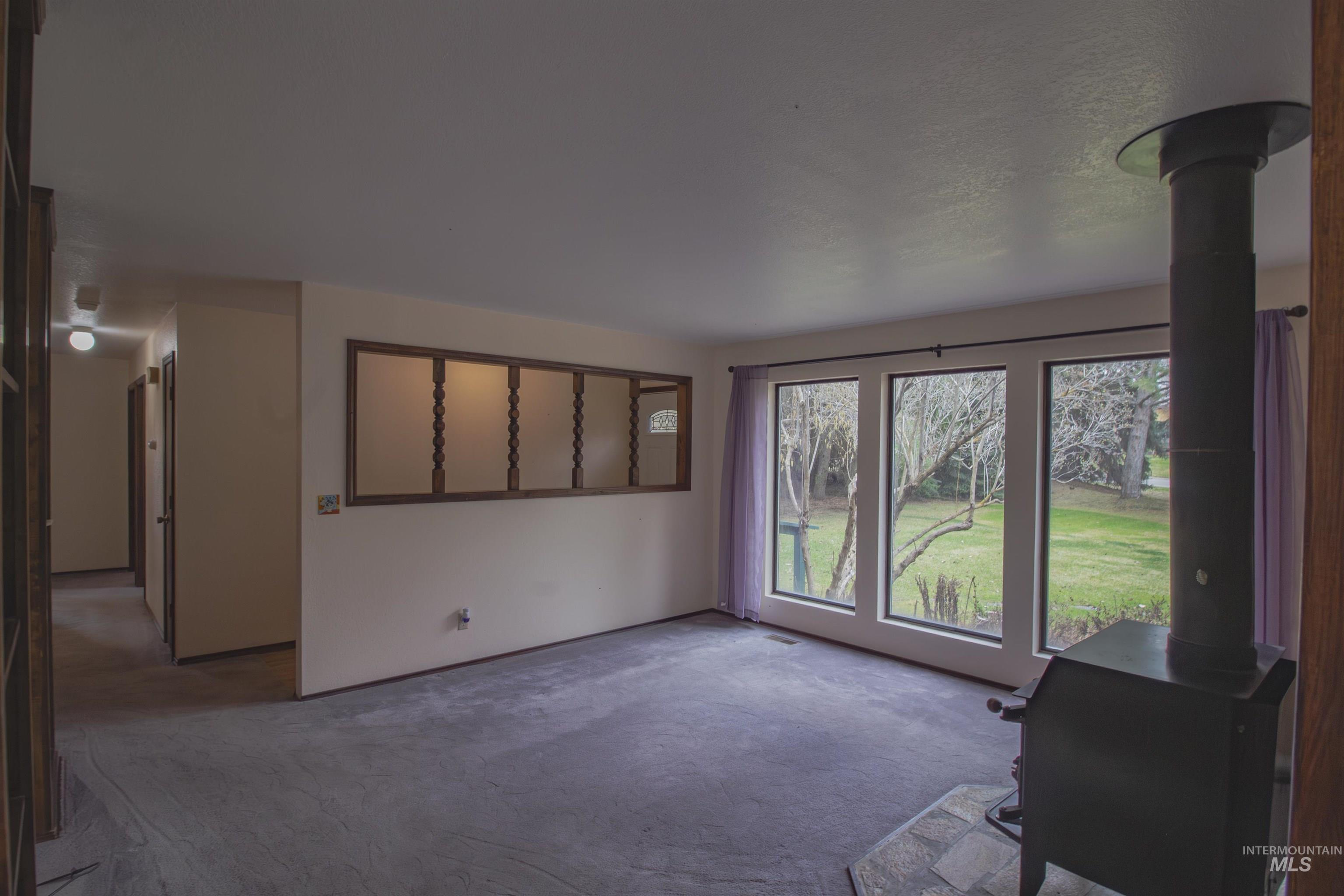 2465 Center Avenue Payette, ID 83661 - Photo 8 of 39 Unfurnished living room featuring a wood stove and carpet floors
