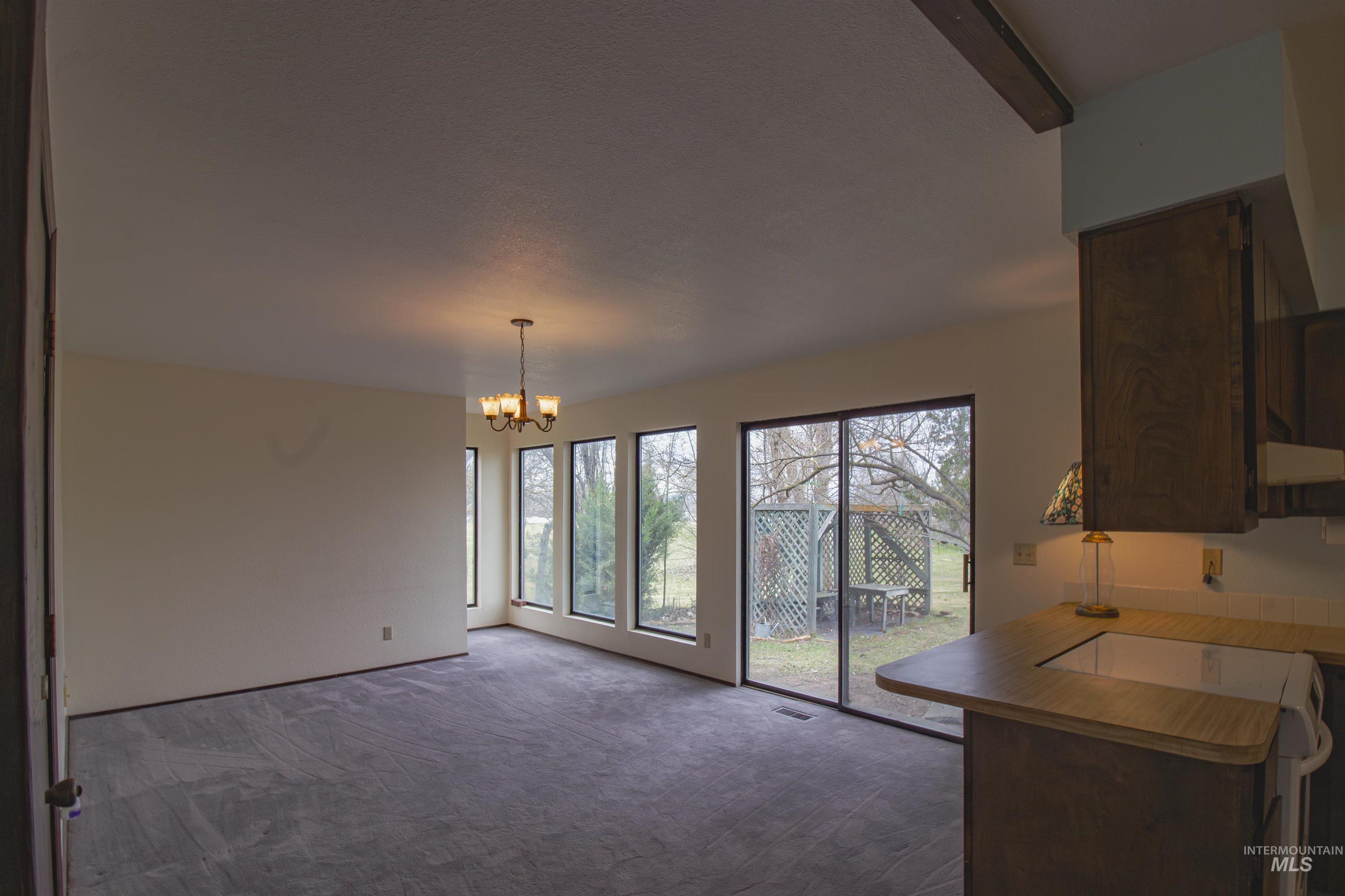 2465 Center Avenue Payette, ID 83661 - Photo 9 of 39 Dining space featuring dark colored carpet and a chandelier