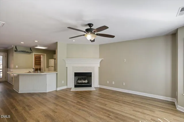 an empty room with kitchen and fireplace