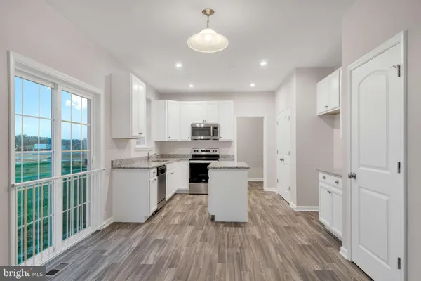 a kitchen with a refrigerator and white cabinets