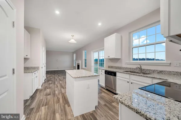 a kitchen with granite countertop a sink stove refrigerator and cabinets