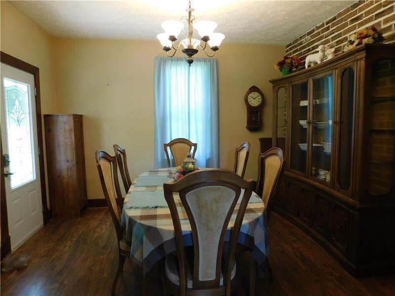 577 Woodside Old Frame Road Smithfield, PA 15478 - Photo 14 of 49 a view of a dining room with furniture a chandelier and wooden floor