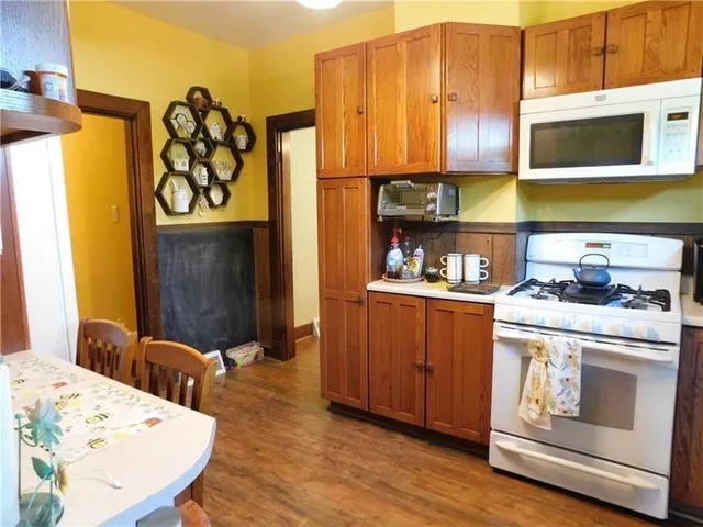a kitchen with stainless steel appliances a stove a microwave a sink and cabinets