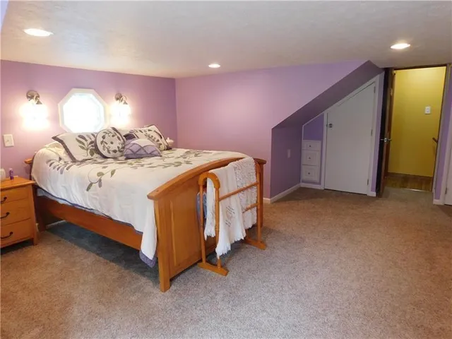 a spacious bedroom with a bed and a lamp