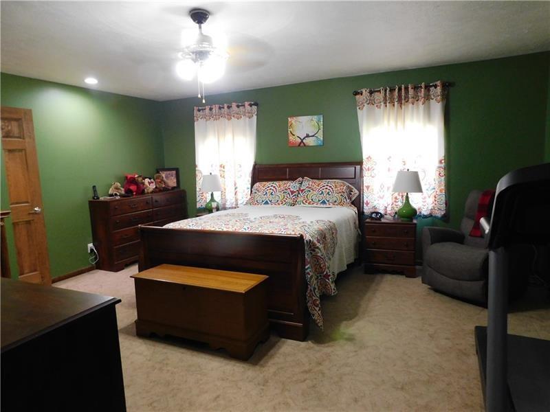 577 Woodside Old Frame Road Smithfield, PA 15478 - Photo 33 of 49 a bedroom with a bed and a chandelier