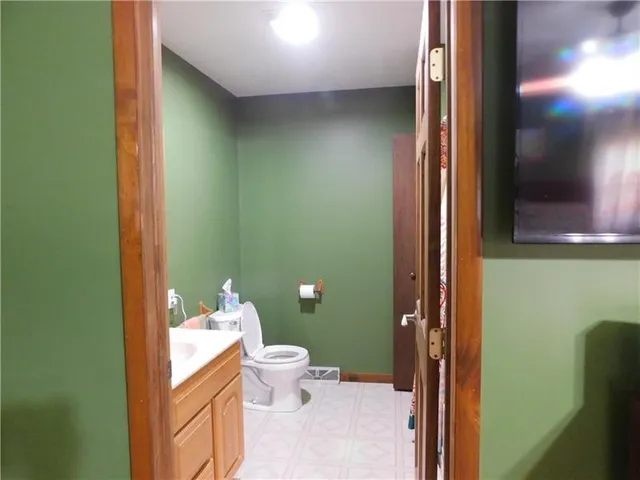 a bathroom with a toilet and a mirror