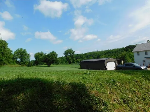 a view of grassy field with trees in the background