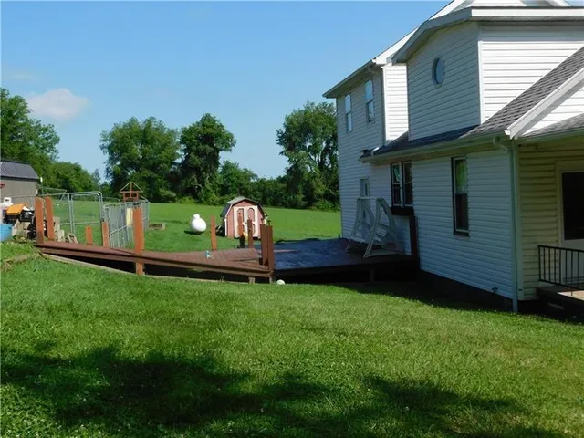 a view of a backyard with a garden and deck
