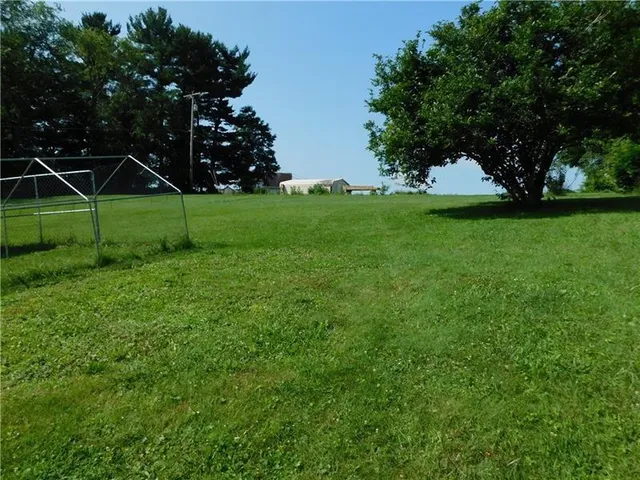 a view of a field of grass and trees