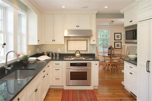 171 Reservoir Road Brookline, MA 02467 - Photo 4 of 8 a kitchen with stainless steel appliances granite countertop a stove and white cabinets
