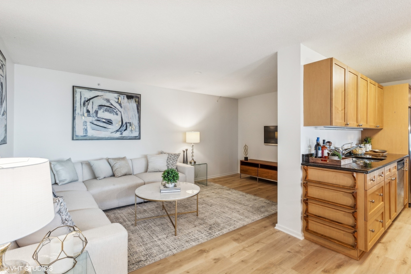 800 Elgin Road, Unit 511 Evanston, IL 60201 - Photo 12 of 29 a living room with furniture and a dining table with kitchen view