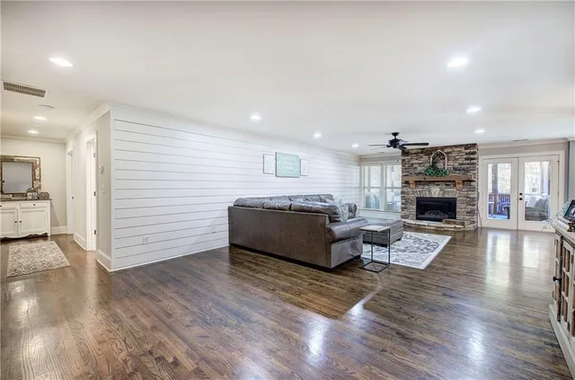 a kitchen with stainless steel appliances granite countertop a sink a stove a refrigerator and island with wooden floor