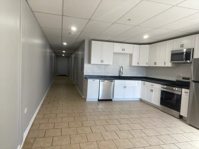 a kitchen with stainless steel appliances granite countertop a stove a sink and a refrigerator