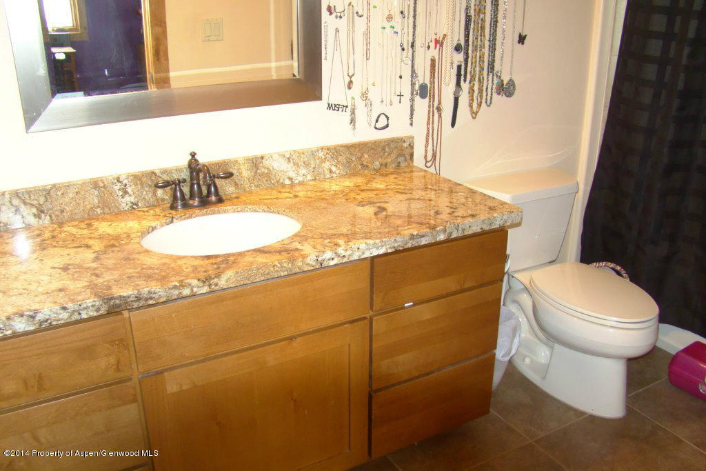551 Deer Run Trail Rifle, CO 81650 - Photo 20 of 20 a bathroom with a granite countertop sink a toilet and mirror
