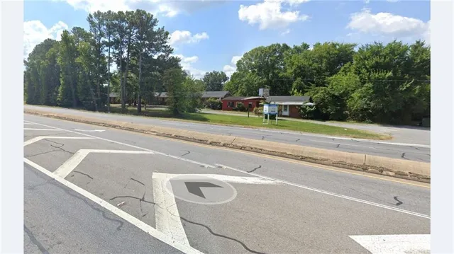 a view of a tennis ground with large trees