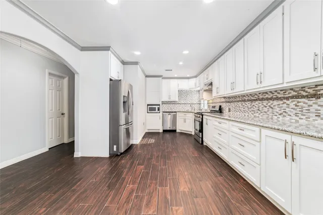 a kitchen with white cabinets and stainless steel appliances