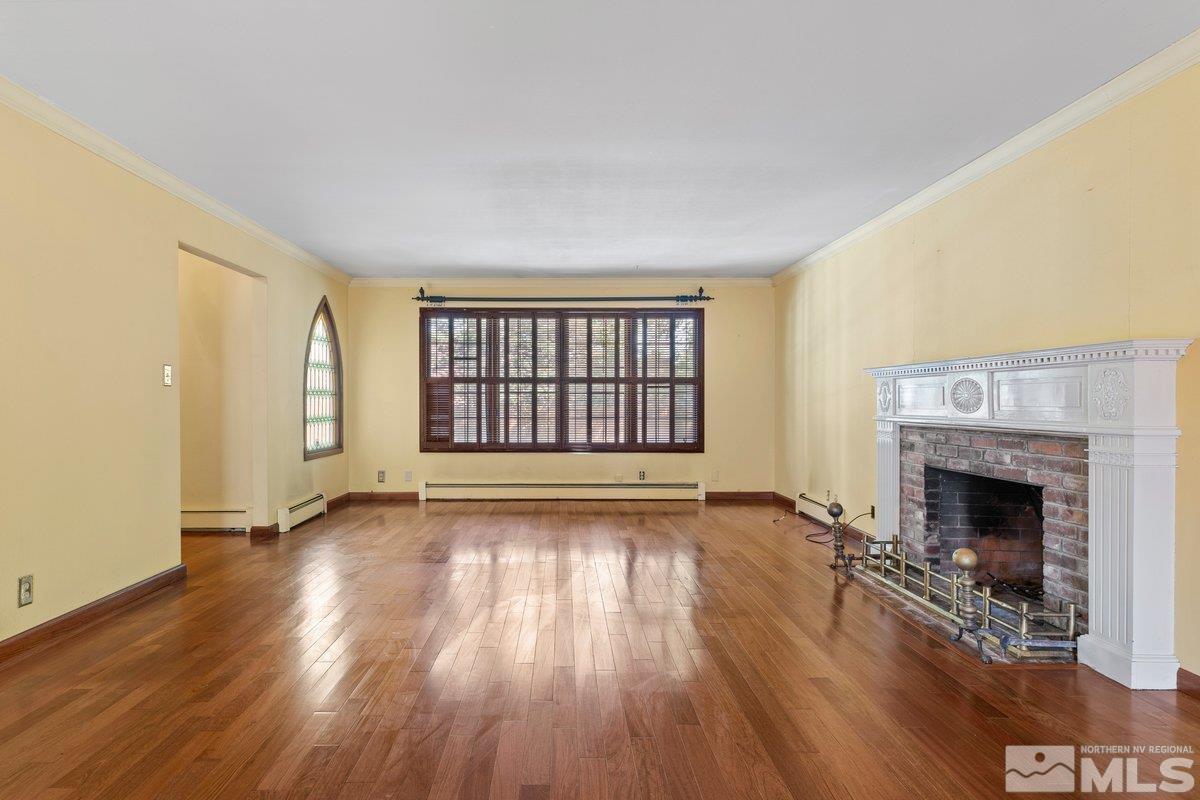 1120 Monroe Street Reno, NV 89509 - Photo 7 of 27 an empty room with wooden floor fireplace and windows