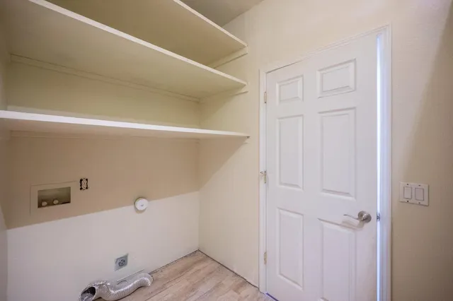 an empty room with closet and a chandelier fan
