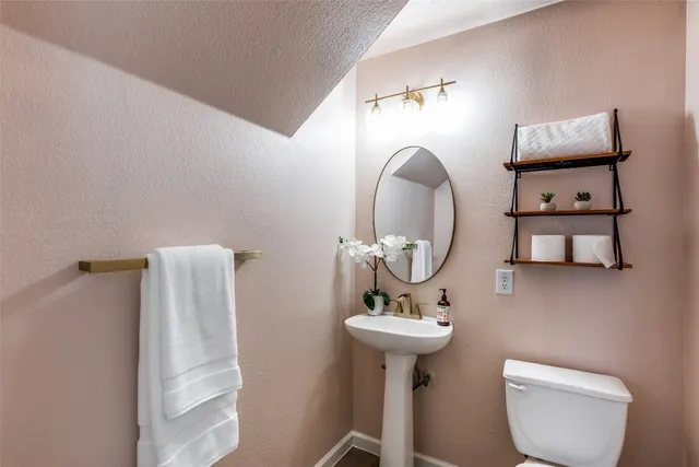 a bathroom with a toilet sink and mirror