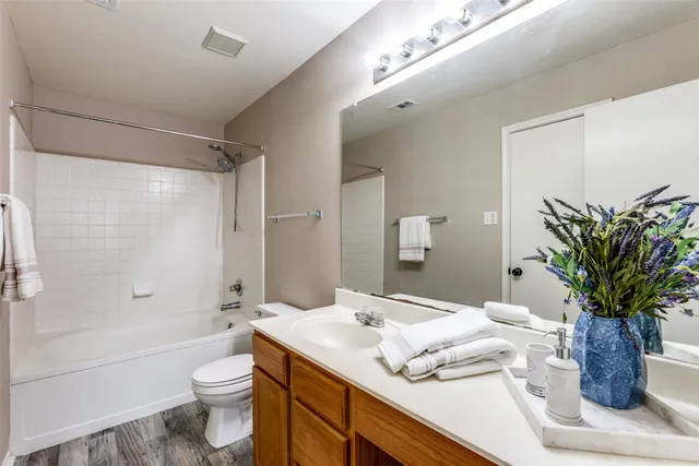 a bathroom with a granite countertop sink a toilet and shower