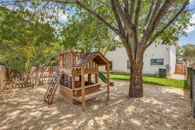 a view of a house with backyard and trees