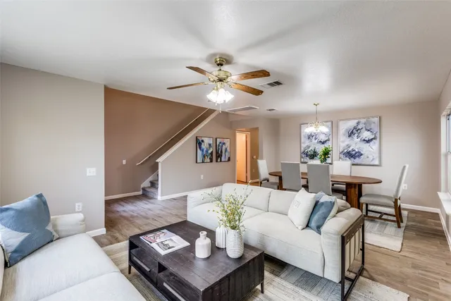 a living room with furniture a chandelier and a table