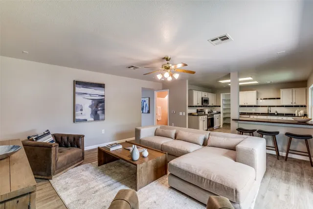 a living room with furniture a dining table and kitchen view