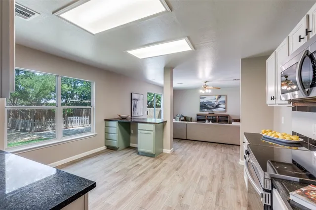 a kitchen with a wooden floor a sink a counter top space and stainless steel appliances