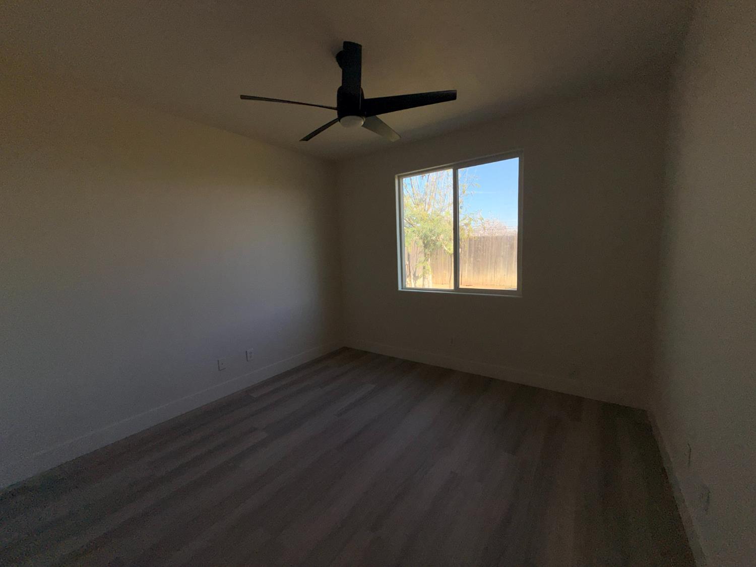 1977 Lemon Avenue Madera, CA 93637 - Photo 14 of 17 a view of an empty room with wooden floor and a window
