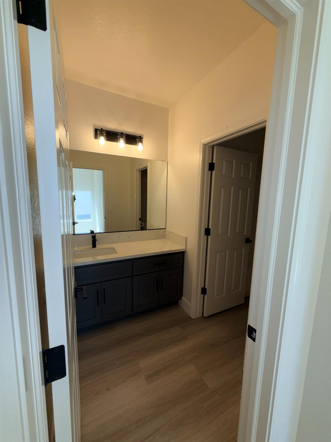 1977 Lemon Avenue Madera, CA 93637 - Photo 9 of 17 a room with a mirror and a wooden floor